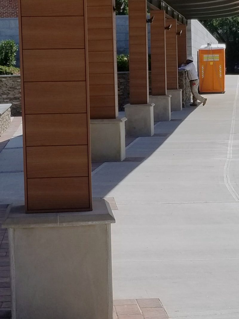 Finished cast stone plinths at the canopy columns with stone veneer walls and new concrete walkway at Roslyn High School
